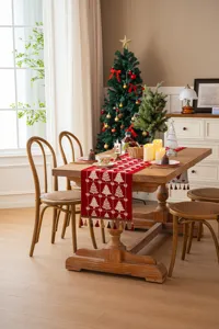 Vista dettagliata del runner da tavola natalizio rosso con alberi jacquard e bellissime nappe.