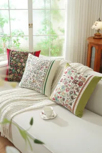 Detailed view of vintage floral jacquard cushion covers arranged cozy on a white sofa scene.