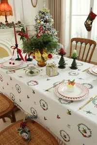 Mantel rectangular con estampado de árbol de navidad con borlas y coronas geométricas.