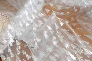 White mesh lace table runner with silver foil Christmas tree print for holiday decor.