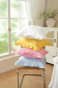 Detailed view of stacked cotton throw pillows with charming ruffles in various pastel colors.