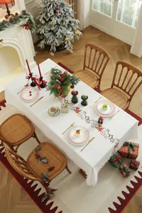 Gedetailleerd overzicht van kerst geborduurde tafelkleed scene met feestelijke tafeldecoratie.