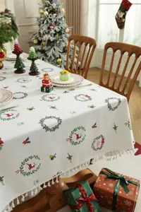 Mantel de Navidad con estampado de corona y ciervo, elegante borde de flecos para mesa de comedor.