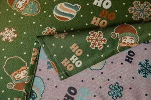 Christmas jacquard fabric detail showing Santa pattern and vintage green cotton blend texture.