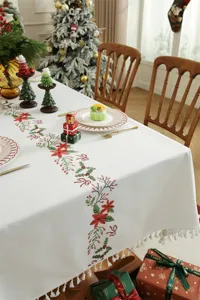 Kerst geborduurd tafelkleed met rode kerstster en feestelijke kwastjes rand details.