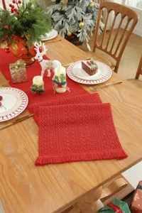 Roter Weihnachtstischläufer mit Häkelstruktur und Fransen, festliche Esszimmerdeko.