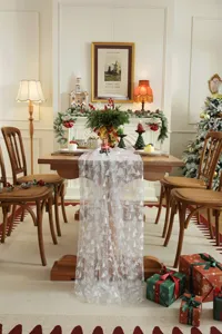 Cozy holiday dining table scene featuring a white mesh lace runner with silver trees.