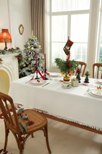 Kerst geborduurd tafelkleed met feestelijk bloemenrankontwerp en elegante franjes.