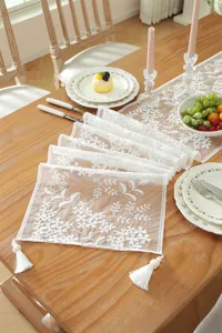 White lace table runner with delicate floral embroidery and tassels for wedding and dining decor view