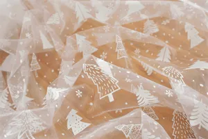 Close-up detail of white sheer mesh table runner featuring silver printed Christmas tree and snow.