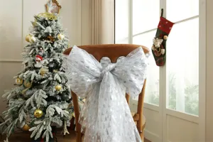 Silver foil Christmas tree print white mesh bow for chair decoration and holiday party setup.