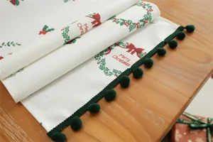 Runner da tavola natalizio con frange a ponpon verdi, stampa ghirlanda floreale per decorazione.