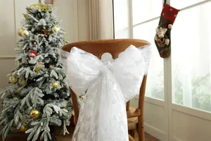 Detail shot of white mesh chair sash with silver Christmas tree print for holiday party decor.