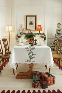 Kersttafelkleed met geborduurde hulstbladeren en feestelijke kwastjes voor tafeldecoratie