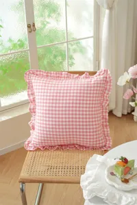 Detailed view of the pink gingham ruffle throw pillow, showing soft cotton texture and cozy style.