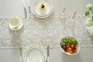 Detailed view of white and gold star and moon lace embroidered table runner decoration.
