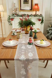 Vista detallada del camino de mesa navideño de encaje blanco con elegantes motivos.