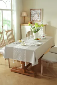 Detailed view of the modern minimalist white lace embroidered table runner with delicate tassels.