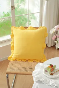 Yellow ruffled throw pillow closeup, French pastoral style cotton cushion detail view.
