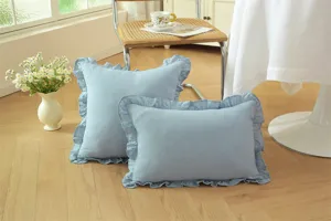 Hermoso detalle de cojín azul con volantes de algodón suave en un ambiente acogedor.