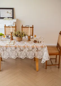 Dettaglio tovaglia di pizzo bianco vintage francese con delicato ricamo floreale in sala da pranzo