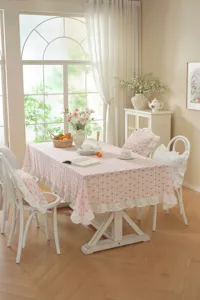 Dettaglio tovaglia in cotone stile francese, motivo fiocco rosa con bordo volant per sala.