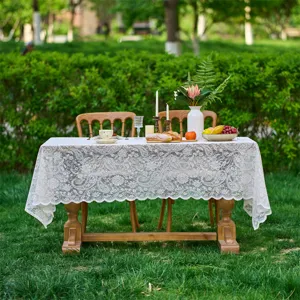Detailed view of elegant white lace tablecloth featuring intricate floral patterns for French style.