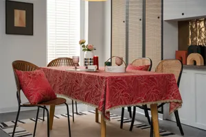 Festive red gold jacquard tablecloth with leaf patterns and lace trim in a dining setup.