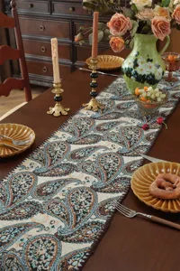 Detailed view of American retro paisley table runner with jacquard design on dark wooden table.