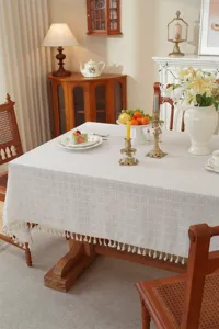 Detailansicht der eleganten einfarbigen Tischdecke mit filigranem Karomuster und Fransen.