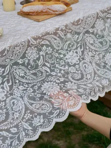 French vintage white lace tablecloth detail, exquisite floral embroidery, elegant home decor prop.