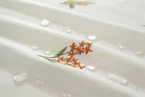 Detailopname van waterdicht katoenen tafelkleed met subtiel geborduurd bloemenpatroon.