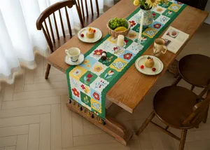 Gros plan détaillé d'un chemin de table jacquard à motif floral vintage avec des pompons.