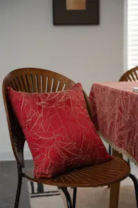 Red jacquard cushion and tablecloth set with gold leaves pattern for festive holiday decor.
