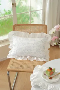 Close-up detail of the French style floral decorative pillow with elegant white ruffled edge.