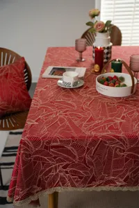 Detailed view of red and gold jacquard leaf tablecloth with elegant lace trim, festive setup.