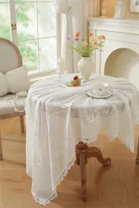 Vue détaillée de la nappe en dentelle blanche brodée française dans un décor élégant.