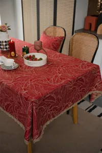 Red jacquard tablecloth with gold leaf pattern and lace trim, perfect for festive dining details.