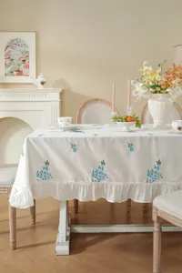 Floral embroidered tablecloth with ruffled edge for dining table decoration details