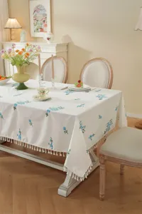 Katoenen tafelkleed met blauw bloemborduursel en franjes voor stijlvolle eettafel.