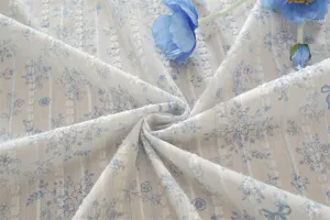 Tessuto jacquard in puro cotone francese con motivo floreale blu e fiocco per decorazioni.