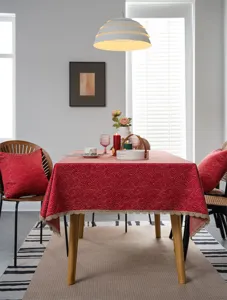Festive red jacquard tablecloth detail shot with elegant gold lace trim for dining room decor