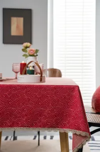 Red jacquard tablecloth with gold wave pattern and lace border for festive wedding decor.