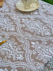 Detailed view of French vintage brown lace tablecloth with intricate floral pattern for decor.