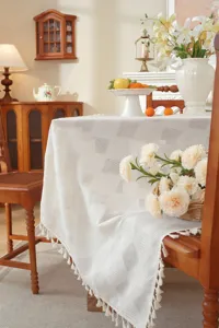 Detailansicht der weißen Jacquard Tischdecke mit Karomuster und Fransen für den Tisch.