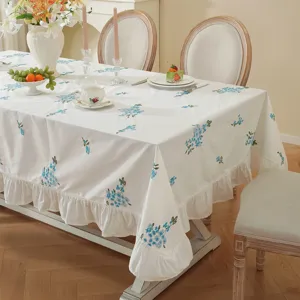Elegant cotton embroidered tablecloth with ruffled edge, floral design for dining room table.