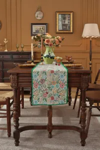 Vintage floral jacquard table runner with green scalloped edge for elegant dining room decor.