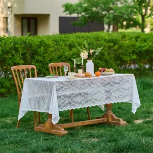 Outdoor garden lace tablecloth scene, elegant white fabric detail for French wedding decor.