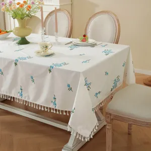Witte katoenen geborduurde bloemen tafelkleed met kwastjes franje voor eetkamer inrichting.
