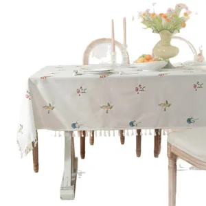 Cotton embroidered tablecloth with elegant floral patterns and fringe edge for dining table.